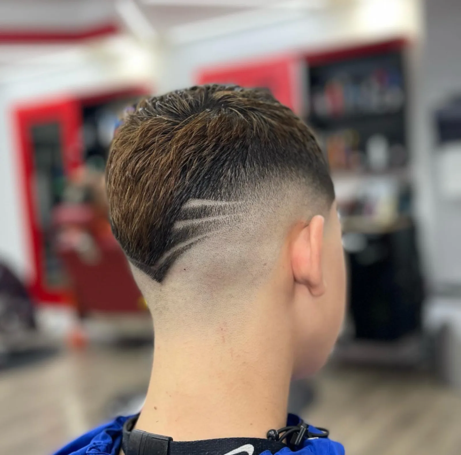 Geometric V-line design carved into a low skin fade