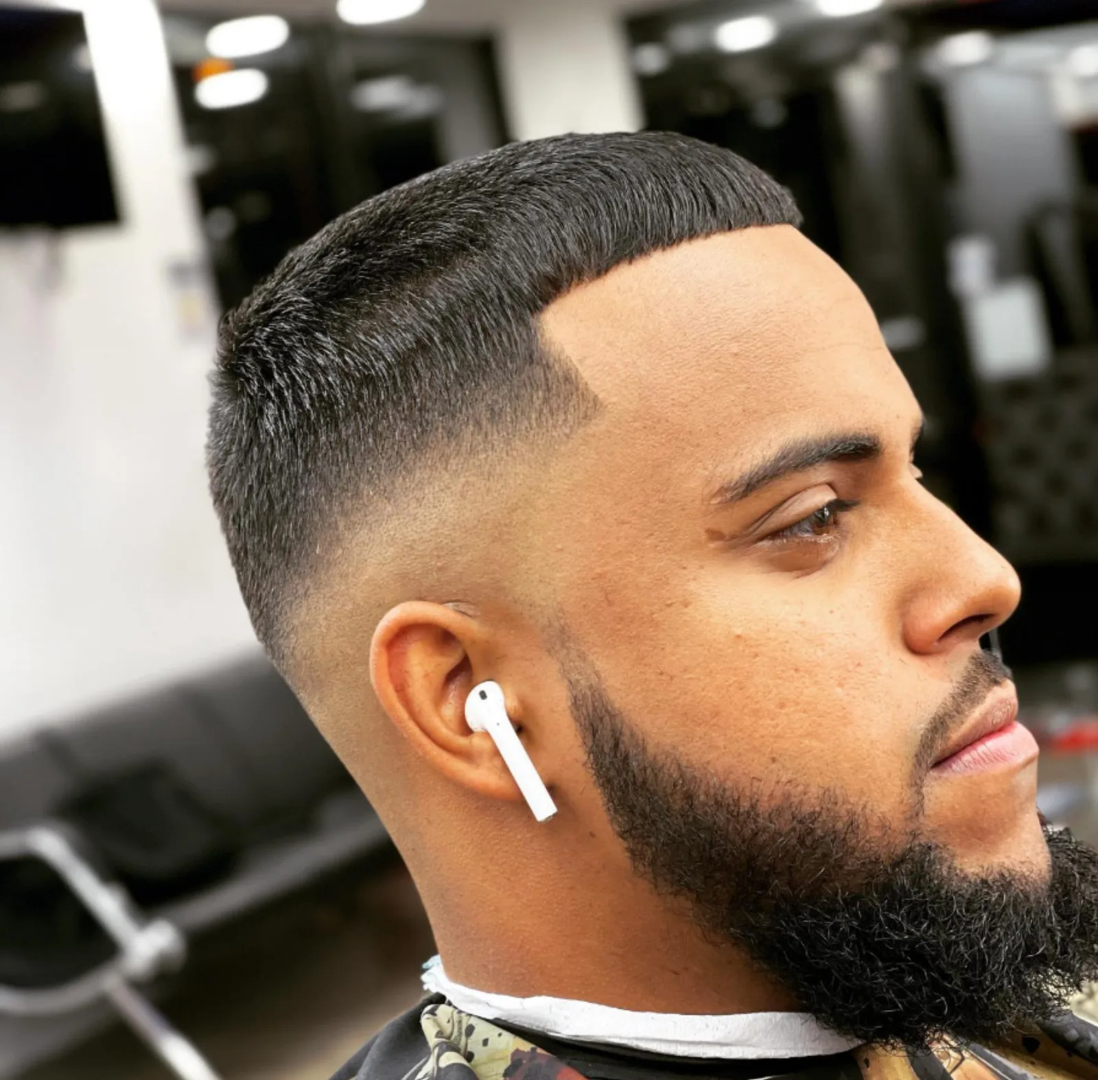 High-and-tight haircut paired with a full sculpted beard