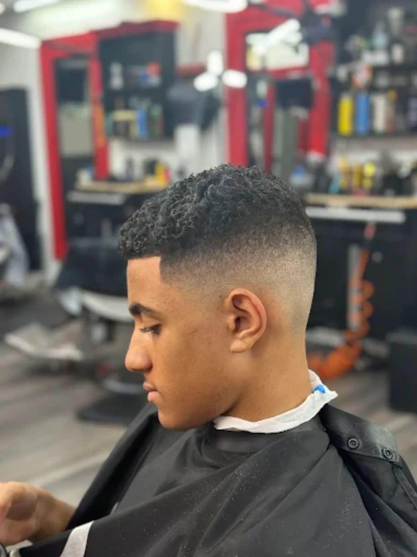 Young customer with a curly top and low skin fade